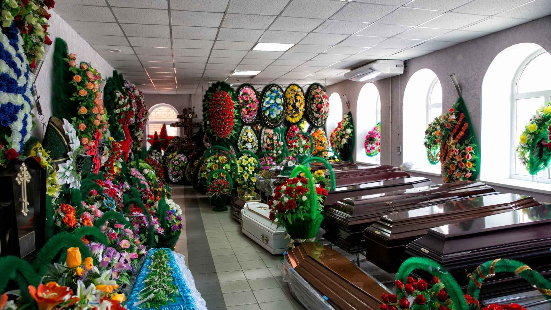 Funeral home showroom with caskets and floral arrangements — Celebrate Life Iowa funeral planning services